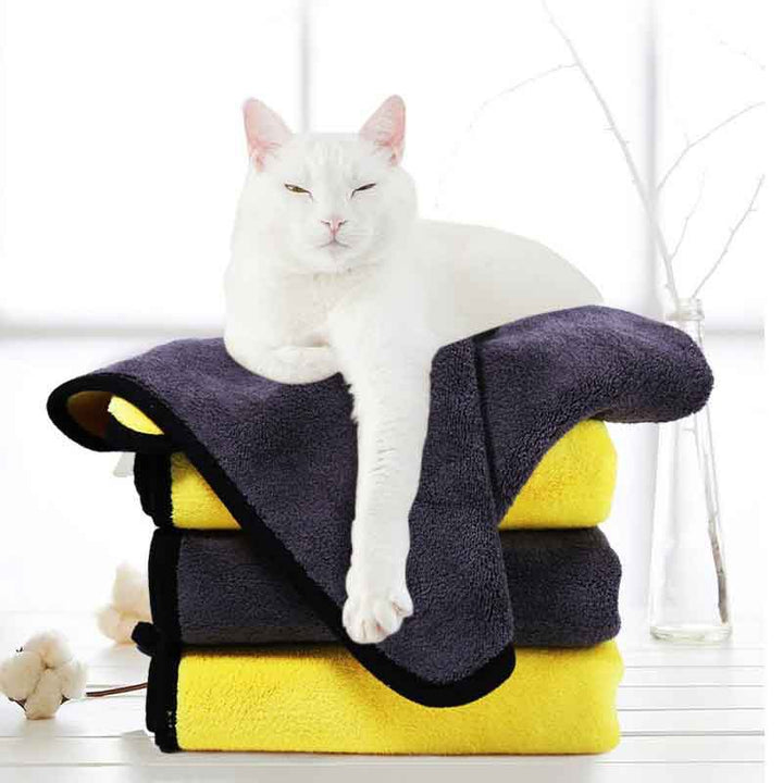 Pet supplies absorbent towel stacked with a relaxed white cat on top, showcasing comfort and style.